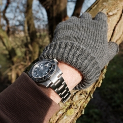 Rolex_wrist_with_gloves_on_a_tree_trunk.jpeg